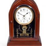 An early 20th century mahogany and inlaid electric mental clock